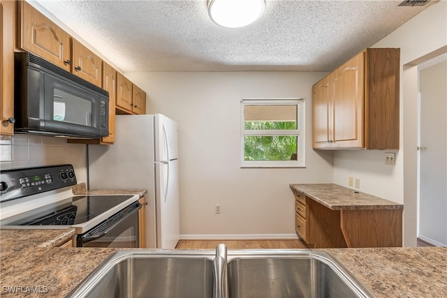 kitchen with decorative backsplash, light hardwood / wood-style flooring, electric range oven, and a textured ceiling