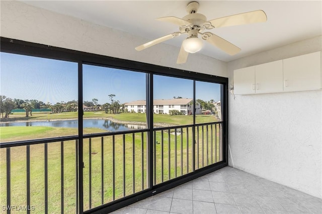 sunroom / solarium featuring a water view and ceiling fan