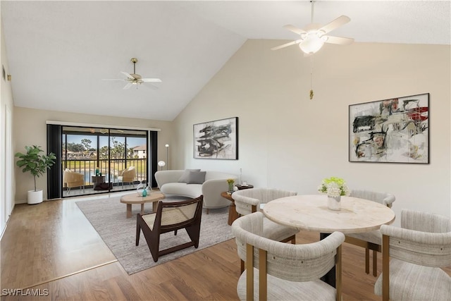 dining area with hardwood / wood-style floors, high vaulted ceiling, and ceiling fan