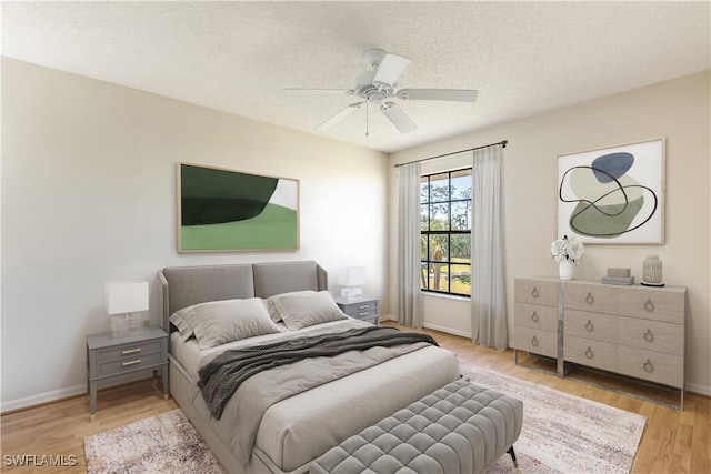 bedroom featuring a textured ceiling, ceiling fan, and light hardwood / wood-style floors