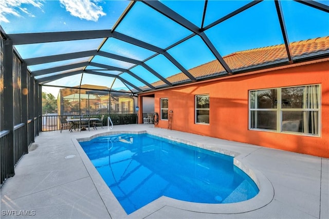 view of pool with a patio area and glass enclosure