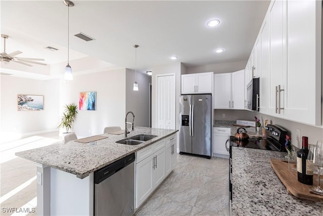 kitchen featuring decorative light fixtures, white cabinetry, sink, and black appliances