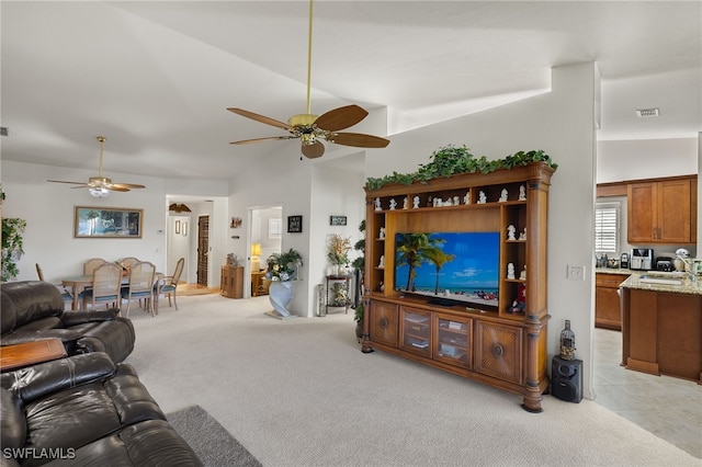 carpeted living room featuring lofted ceiling, sink, and ceiling fan