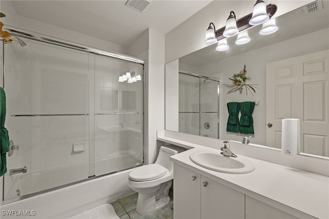 full bathroom with tile patterned flooring, vanity, bath / shower combo with glass door, and toilet