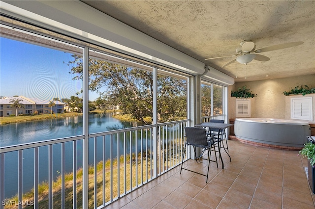 unfurnished sunroom with a water view and ceiling fan