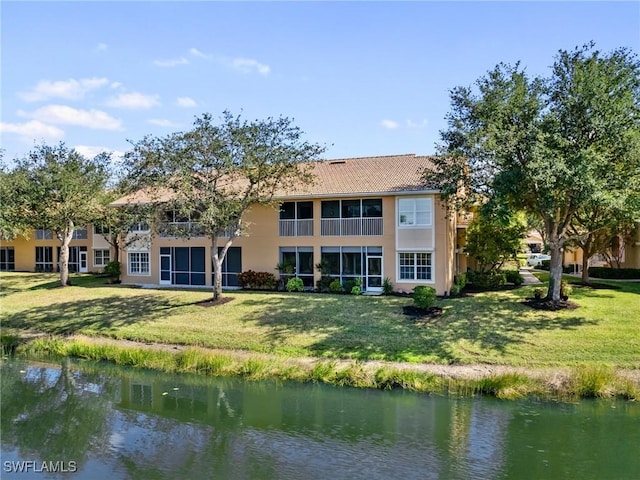 back of house featuring a yard and a water view