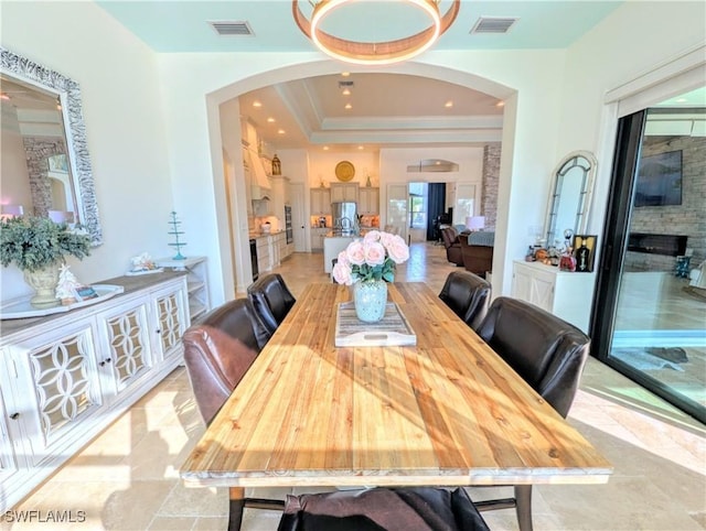 dining space with visible vents, a raised ceiling, arched walkways, and recessed lighting