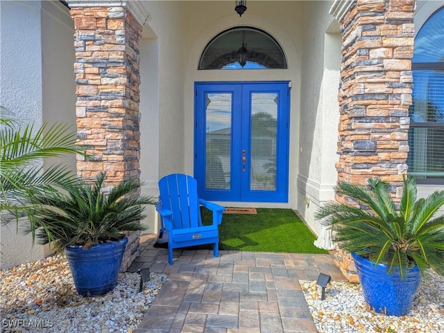 view of exterior entry with french doors and stucco siding