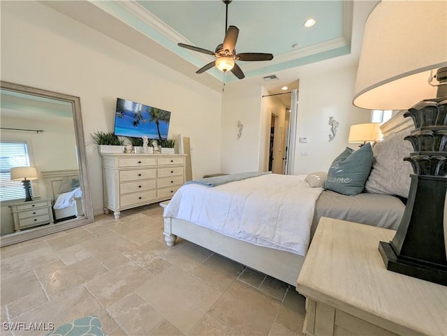 bedroom with ceiling fan, ornamental molding, stone finish floor, and a raised ceiling