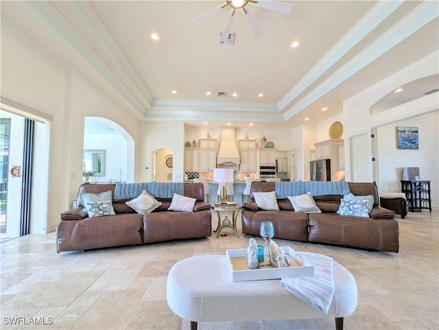 living room featuring ornamental molding, a wealth of natural light, a raised ceiling, and visible vents