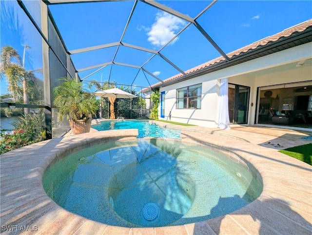 view of pool with a lanai, a patio area, and a pool with connected hot tub