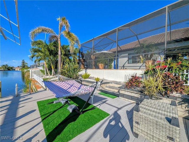 view of patio with a lanai and a water view