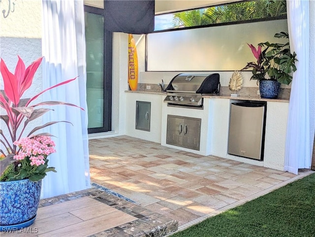 view of patio / terrace featuring exterior kitchen and a grill