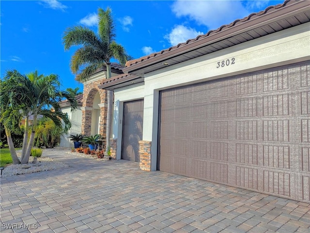 garage with decorative driveway