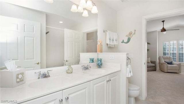 bathroom featuring vanity, ceiling fan with notable chandelier, and toilet