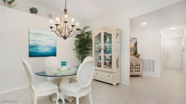 tiled dining room featuring a notable chandelier