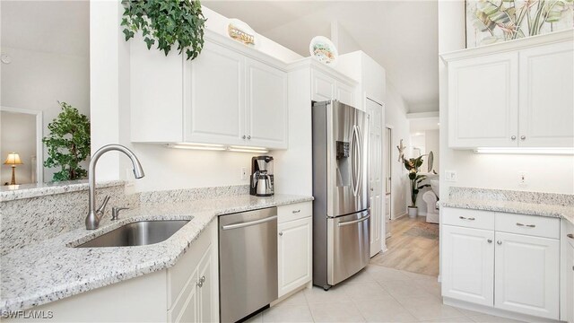 kitchen featuring sink, light stone countertops, white cabinets, and appliances with stainless steel finishes