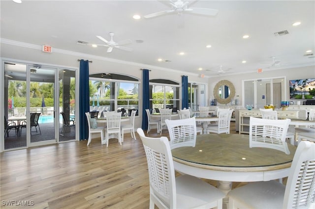 dining space featuring ceiling fan, ornamental molding, and light hardwood / wood-style flooring