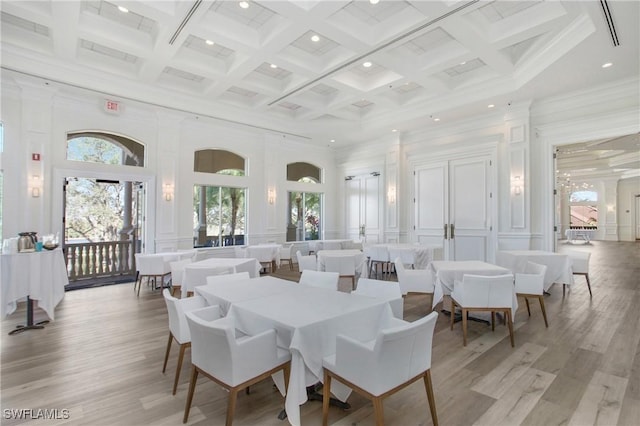 dining area with coffered ceiling, a towering ceiling, and beam ceiling