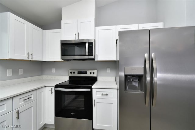 kitchen with white cabinetry, stainless steel appliances, and light stone counters