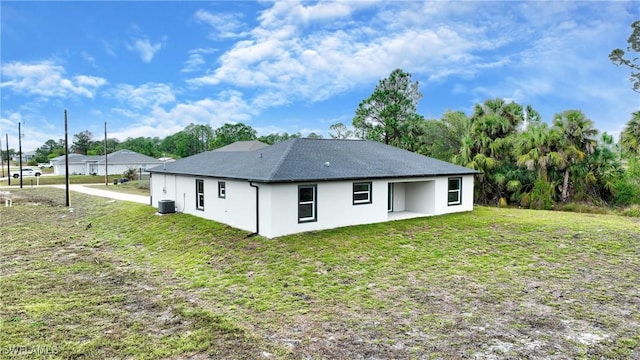 back of house featuring cooling unit and a lawn