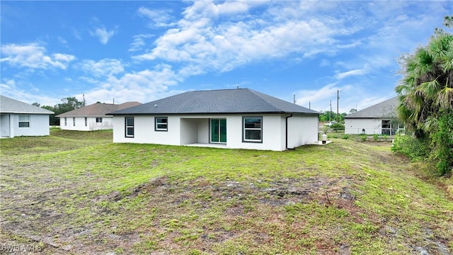 rear view of property featuring a patio and a yard