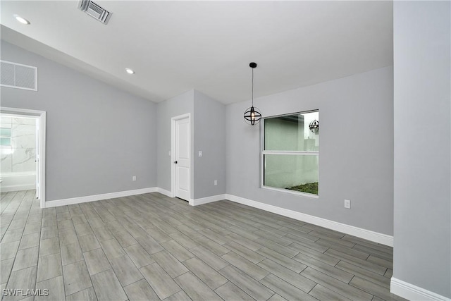 empty room featuring lofted ceiling