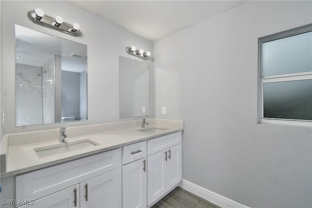 bathroom with vanity, tile patterned flooring, and a tile shower