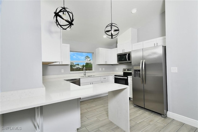 kitchen featuring hanging light fixtures, appliances with stainless steel finishes, sink, and white cabinets