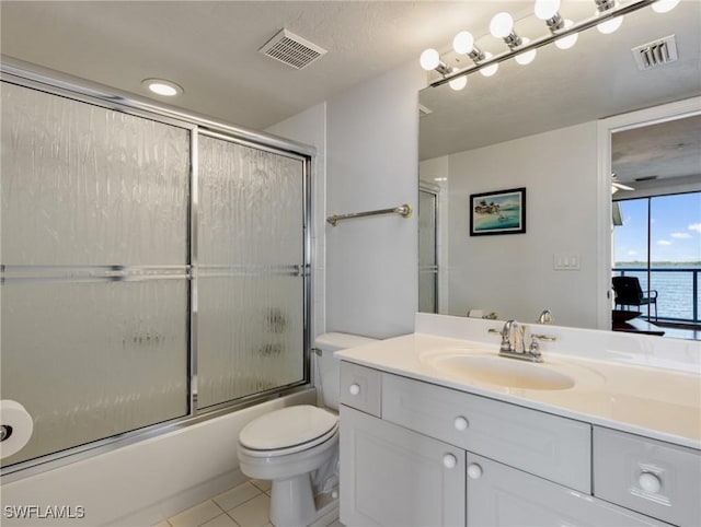 full bathroom with combined bath / shower with glass door, vanity, toilet, a water view, and tile patterned floors