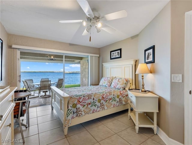 bedroom with a water view, ceiling fan, and light tile patterned flooring