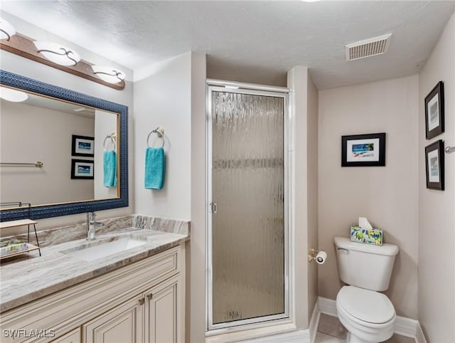 bathroom featuring a shower with door, tile patterned flooring, vanity, a textured ceiling, and toilet