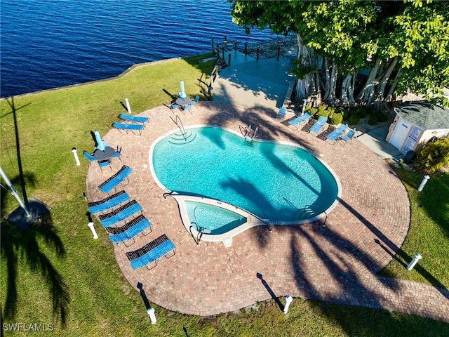 view of swimming pool with a water view, a lawn, and a patio area