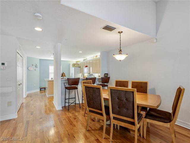 dining space with light hardwood / wood-style floors