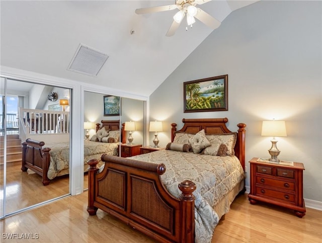 bedroom with lofted ceiling, two closets, ceiling fan, and light hardwood / wood-style flooring