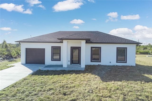 prairie-style home featuring a garage and a front lawn