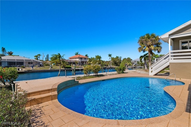 view of pool featuring a water view and a patio area