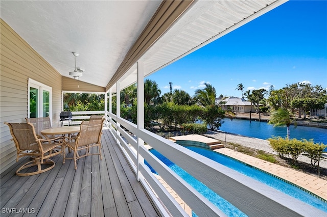 wooden terrace with area for grilling and a water view