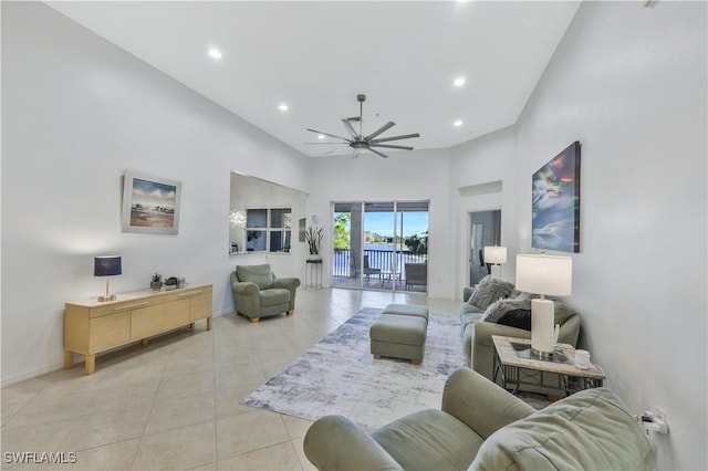 living room with light tile patterned flooring, a towering ceiling, and ceiling fan