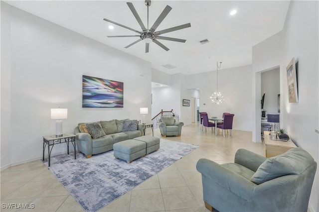 tiled living room featuring ceiling fan with notable chandelier