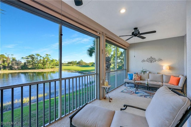 sunroom featuring a water view and ceiling fan