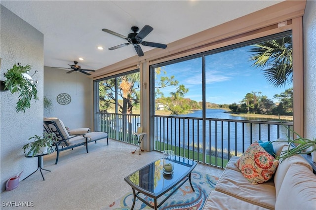 sunroom with a water view and ceiling fan