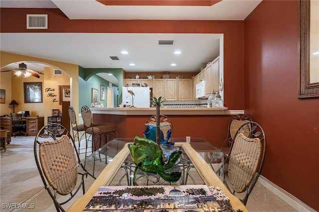 dining area featuring arched walkways, visible vents, and ceiling fan