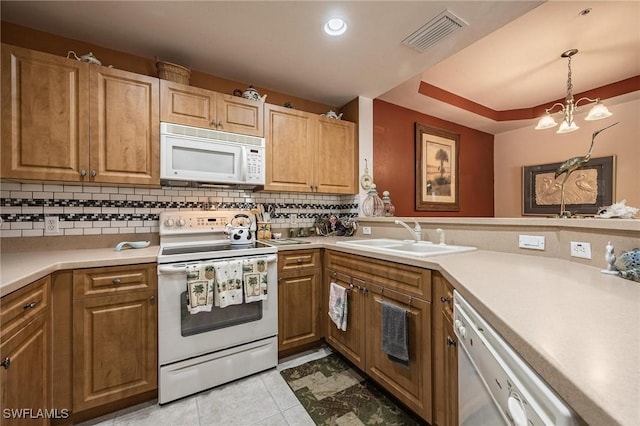 kitchen with white appliances, visible vents, a sink, and backsplash