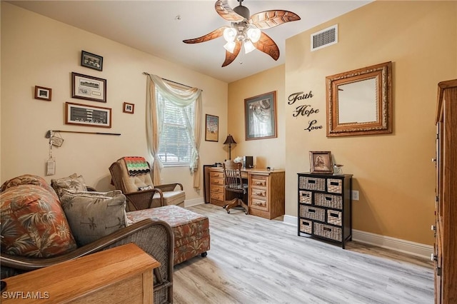 living area featuring light wood-style floors, baseboards, visible vents, and ceiling fan