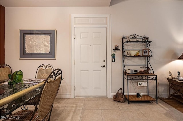 foyer with light tile patterned floors and baseboards