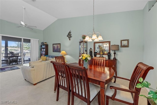 carpeted dining space featuring lofted ceiling and ceiling fan with notable chandelier