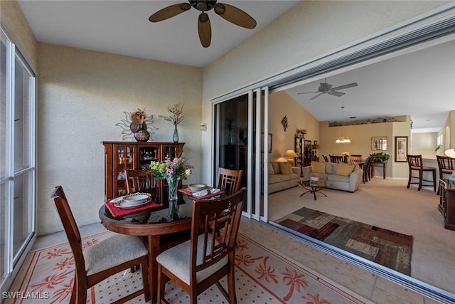 carpeted dining area with vaulted ceiling and ceiling fan