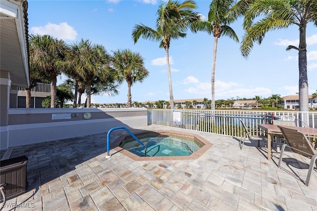 view of pool featuring a community hot tub, a patio, and a water view