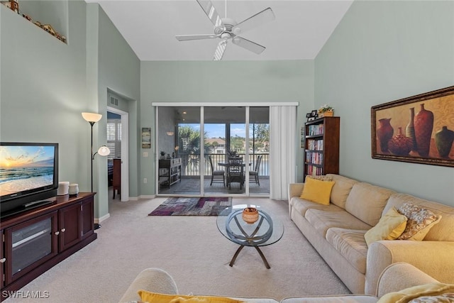 carpeted living room with ceiling fan and a towering ceiling